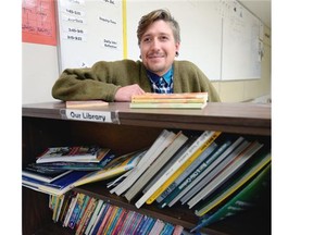 Nate Polsfut, a teacher at Kitchener Community School, with part of the school’s current book collection.