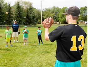Noah Kaytor, right, of the Regina Pacers midget AA baseball team runs a throwing clinic for young players at Queen Elizabeth Park on Saturday. 
  
 Michael Bell/Leader-Post