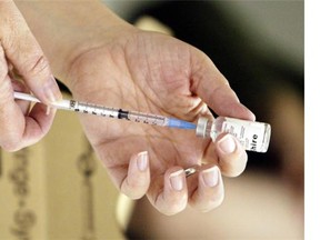 A nurse loads a syringe with a vaccine on Oct. 23, 2004 in Victoria. (THE CANADIAN PRESS/Chuck Stoody)