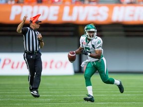 An official throws a penalty flag as Saskatchewan Roughriders’ quarterback Kevin Glenn looks for an open receiver during the first half of a CFL football game against the B.C. Lions in Vancouver, B.C., on Friday July 10, 2015.