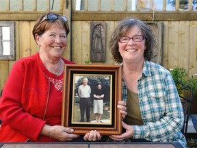 Paulette Holmes, left, and Candy “Dee Dee” Frederiksen, right, pose with a photo of their parents Ralph and Caroline Gronnerud.