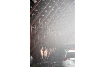 People take cover under the grand stands during a massive downpour at the Craven Country Jamboree on Saturday July 11, 2015.
