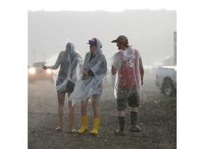 People walk muddy trails during a massive downpour at the Craven Country Jamboree on Saturday July 11, 2015.