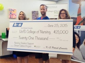 Kim Poley, Mike Gerrand and Marie Dietrich Leurer hold up a check that will help fund the mentorship program between nursing students and street-involved youth.
