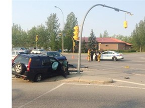 Police attend to the scene of a crash at Lewvan Drive and 13th Avenue Tuesday morning.