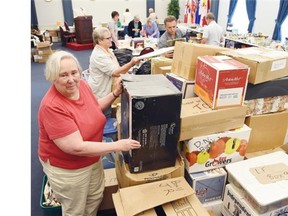 Janice Routley, head of the organizing committee for the Government House Historical Society’s 16th annual antiques and collectibles auction, in the midst of the “cyclone” of donations gathered throughout the year.