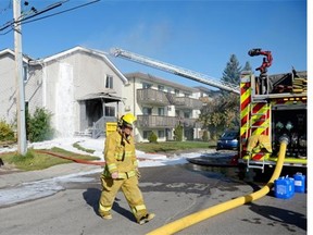 Regina Fire and Protective Services members contain a house fire at 1454 Angus St. in Regina, Sask. on Saturday morning Sep. 12, 2015. (Michael Bell/Regina Leader-Post)