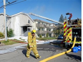 Regina Fire and Protective Services members contain a house fire at 1454 Angus St. in Regina, Sask. on Saturday morning Sep. 12, 2015.