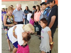 REGINA, SK: JULY 08, 2015 --  Saskatchewan Lt.-Gov. Vaughn Solomon Schofield gets a hug from fire evacuee Nikita Ross 4 years as her sister Shanikka Ross (R) 8 years both from La Ronge, SK watches while Gov. Gen. David Johnston and his wife Sharon look on at the Credit Union EventPlex in Regina on July 08, 2015. (DON HEALY/Regina, Leader-Post) (Story by Nathan Liewicki) (NEWS)