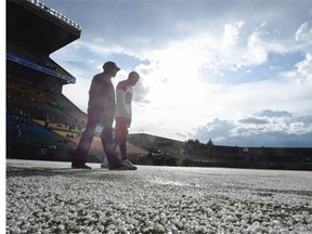 Calgary Stampeders wide receiver Kamar Jorden (#88) and a Calgary coach walk on hail on the field at Mosaic Stadium during warmup after a storm blew through Regina before a CFL preseason game at Mosaic Stadium in Regina on June 19, 2015.