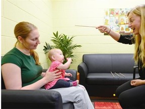Amber Mason, from left, and her 6-month-old daughter Annabelle take part in a task test being performed by University of Regina Early Cognitive Development Lab lab coordinator Tasha Nagel in Regina on Tuesday.
