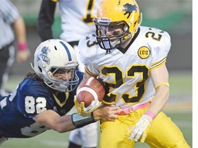 Carter Hewson (R) with the Luther Lions tries to break the tackle of Skylar Deschambault with the O'Neill Titans during RIFL football at Mosaic Stadium in Regina on October 22, 2015.