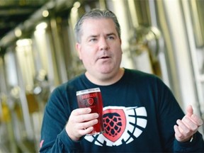 Rebellion co-owner Jamie Singer holds up a Pink Ribbon Hibiscus Ale in Regina on Thursday.  The Ale is in recognition Breast Cancer Awareness Month.