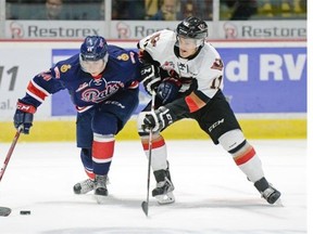 Regina Pats forward Connor Hobbs (#44) is shadowed by Calgary Hitmen forward Beck Malenstyn (#11) during a game held at the Brandt Centre in Regina, Sask. on Sunday Oct. 4, 2015. (Michael Bell/Regina Leader-Post)