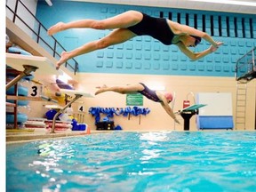 Regina Piranhas swimmers and sisters Jenna, top,  and Elizabeth Johnson practice their starts at the University of Regina pool in Regina on Tuesday.