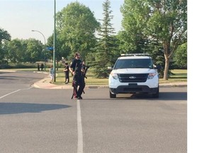 Regina Police Service officers walk along 12th Avenue North following an incident that saw more than a dozen cruisers converge on a north Regina home Thursday evening. NATHAN LIEWICKI/The Leader-Post