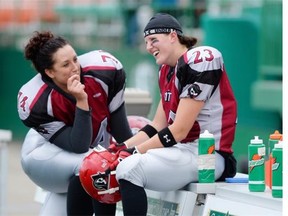 Regina Riot runningback Carmen Agar (#23) chats with teammate Ashley Bisskey (#74) during a Western Women’s Canadian Football League playoff game held at Mosaic Stadium on June 21, 2015.