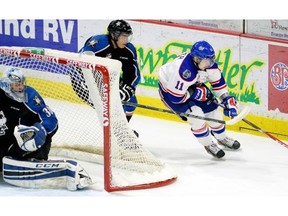 Pats Taylor Cooper rounds the Kootenay Ice net with Ice Rinat Valiev 24 in persuit during second period  WHL action between the Kootenay Ice and Regina Pats at the Brandt Centre in Regina February 25, 2015.