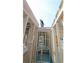 Justin Walker of Walker Homes screws sub-flooring down on a home in east Regina July 8, 2015.