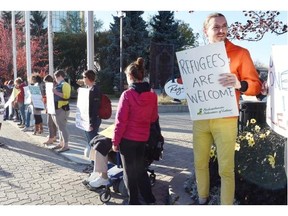 Nathaniel Cole (R) participates in a refugees welcome rally taking place outside Regina city hall on September 28, 2015.