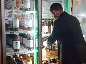 Todd MacKay, Canadian Taxpayers Federation, grabs a case of beer from he Bushwackers off-sale in Regina on Friday.