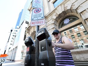 Matt Braun plugs a parking meter on the 2000 block of 11th Avenue in Regina on August 11, 2015.