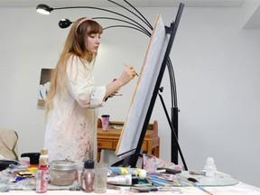 Allee Olmstead paints in her studio in Regina on Sunday.