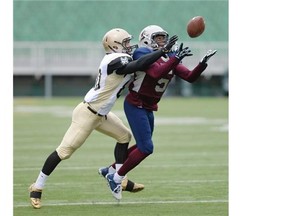 Regina Thunder defensive back Menedum Menegbo, right, nearly intercepts a pass intended for Edmonton Huskies wide receiver Dylan Stanton during a windy PFC game Sunday at Mosaic Stadium.