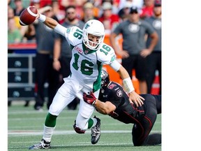 Riders quarterback Brett Smit (left) tries to evade Ottawa’s Justin Capicciotti during first half of Sunday’s 35-13 loss to the host Redblacks (THE CANADIAN PRESS/Justin Tang)