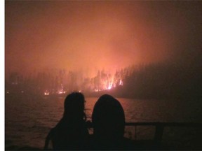 Lac La Ronge Indian Band Chief Tammy Cook-Searson and Councillor Linda Charles survey the Ant Island fire by boat early Monday morning