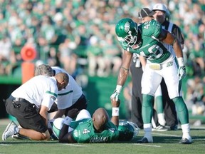 Roughriders quarterback Darian Durant, 4, receives encouragement from teammate Jeff Knox Jr., right after suffering a ruptured left Achilles tendon on Saturday. 
  
 Michael Bell/Leader-Post