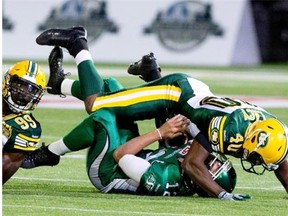 Saskatchewan quarterback Tino Sunseri (12) is sacked by Edmonton’s Deon Lacey (40) on Saturday (THE CANADIAN PRESS/Jason Franson)