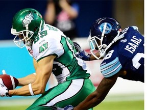 Saskatchewan Roughriders' Chris Getzlaf, 89, scores a touchdown as the Toronto Argonauts' Brandon Isaac defends during CFL action in Toronto on Aug. 8. Getzlaf scored two touchdowns in that game, but has been sidelined by a foot injury ever since. He could return for Friday's game in Hamilton.