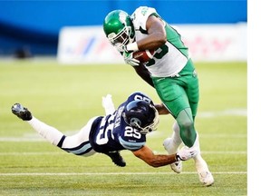 Saskatchewan Roughriders’ Jerome Messam (33) runs the ball against Toronto Argonauts’ Isaiah Green (25) during first half CFL action in Toronto on Saturday Aug. 8, 2015.