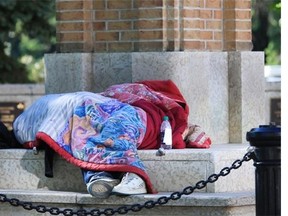 A homeless person sleeping on Spadina Cres. at the clock in Saskatoon on June 1, 2015.