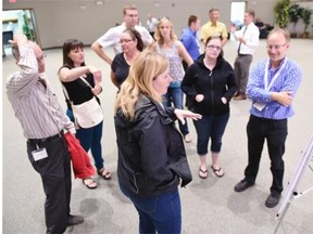 Shauna Poirer (L) talks with Scott Thomas (R) a senior engineer with the City of Regina at an open house held at Rosewood Park Alliance Church to discuss the relocation of a school from the Skywood neighbourhood to Coopertown in Regina on Tuesday. (DON HEALY/Regina Leader-Post)