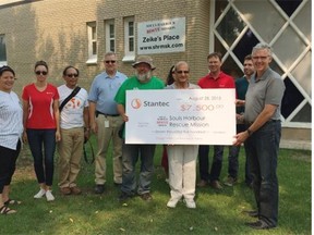 Souls Harbour executive director Joe Miller (in green) accepts a cheque from Stantec.