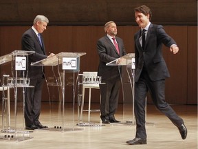 Liberal Leader Justin Trudeau, right, walks on stage as Conservative Leader Stephen Harper and NDP Leader Tom Mulcair prepare for the Munk Debate on Canada's foreign policy in Toronto, on Monday, Sept. 28, 2015.