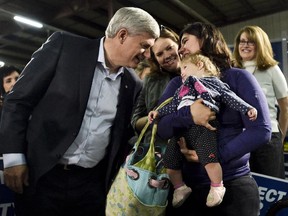 Conservative Leader Stephen Harper, left, talks with mothers and their children after speaking during a campaign stop in Saskatoon, Sask, on Wednesday, October 7, 2015.