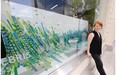 Terri Fidelak, artist-in-residence at the Creative City Centre, stands in front of one of the storefront art pieces that is part of the Pop Up Downtown exhibit.