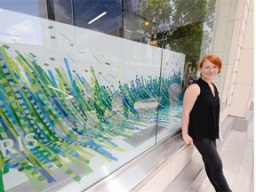 Terri Fidelak, artist-in-residence at the Creative City Centre, stands in front of one of the storefront art pieces that is part of the Pop Up Downtown exhibit.