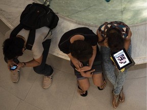 This picture taken on March 19, 2013 shows people using their smartphones and tablets in a shopping mall in Bangkok.