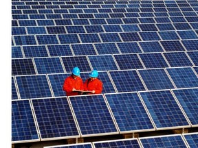 Workers check solar panels at a solar power station on a factory roof in Changxing in eastern China's Zhejiang province.