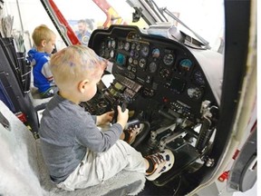 Three-year-old Preston Oldfield, foreground, and 5-year-old Roch Wheeler sit in the pilot seats of the STRAS Air Ambulance in Regina on Friday.  STARS held an open house on Friday to help mark the STARS 30th anniversary.
