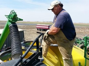 Todd Lewis fills up an air seeder with fertilizer on his field south of Regina in this file photo from 2013. Sales of fertilizer, chemical and other agricultural supplies were lower in June than May, according to Statistics Canada. (Mark Melnychuk / Regina Leader-Post)