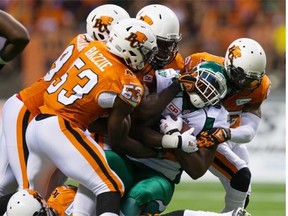 It took a pride of B.C. Lions to bring down Saskatchewan’s Jerome Messam on July 10 (THE CANADIAN PRESS/Darryl Dyck)