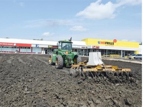 A tractor with a discer attached works the dirt for a major parking lot refurbishment at Rosemont Shopping Centre in Regina on August 05, 2015. DON HEALY/Regina, Leader-Post