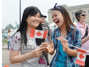 Tram and Jen Vu cheer for Western Canada’s Strongest Man competition at Canada Day celebrations held near the Legislative Assembly in Regina on Wednesday July 1, 2015.