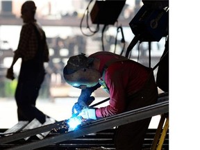 Welders work in the fabrication area at JR’s Welding shop in Regina on July 9, 2014.