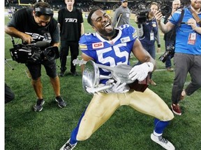 Winnipeg Blue Bombers' Jamaal Westerman (55) strums the Banjo Bowl after his team defeated the Saskatchewan Roughriders in CFL action in Winnipeg on Saturday. 
  
 John Woods/The Canadian Press